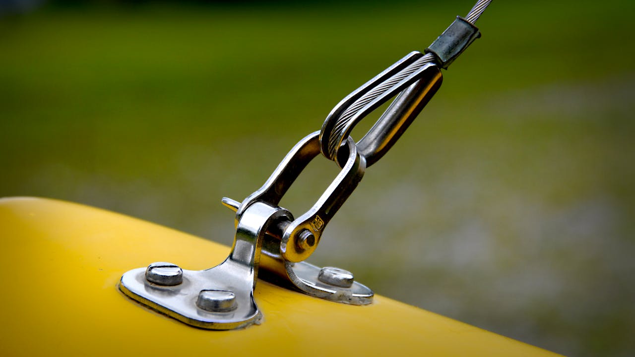 Close-up of stainless steel rigging and yellow surface, emphasizing durability.
